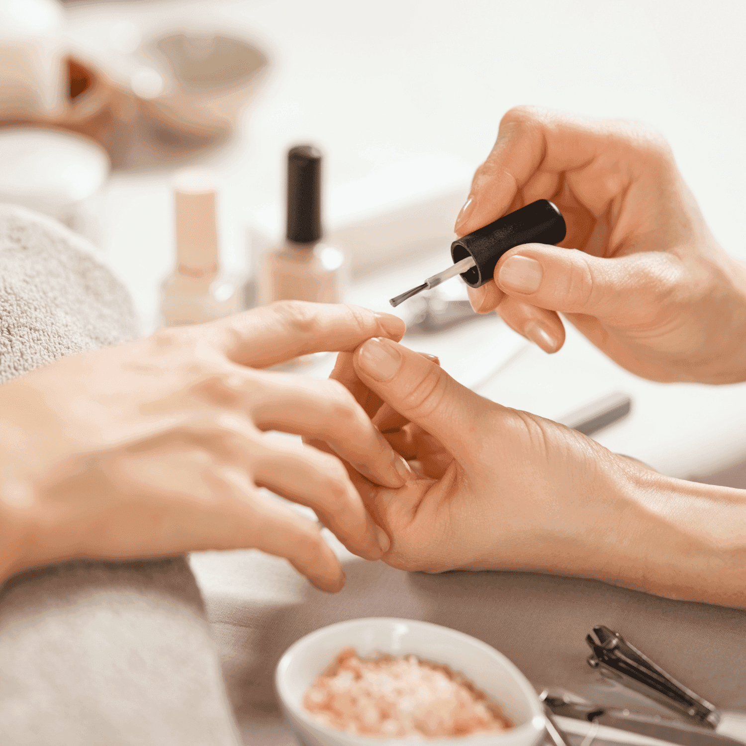 Nail technician applying polish during a manicure session.