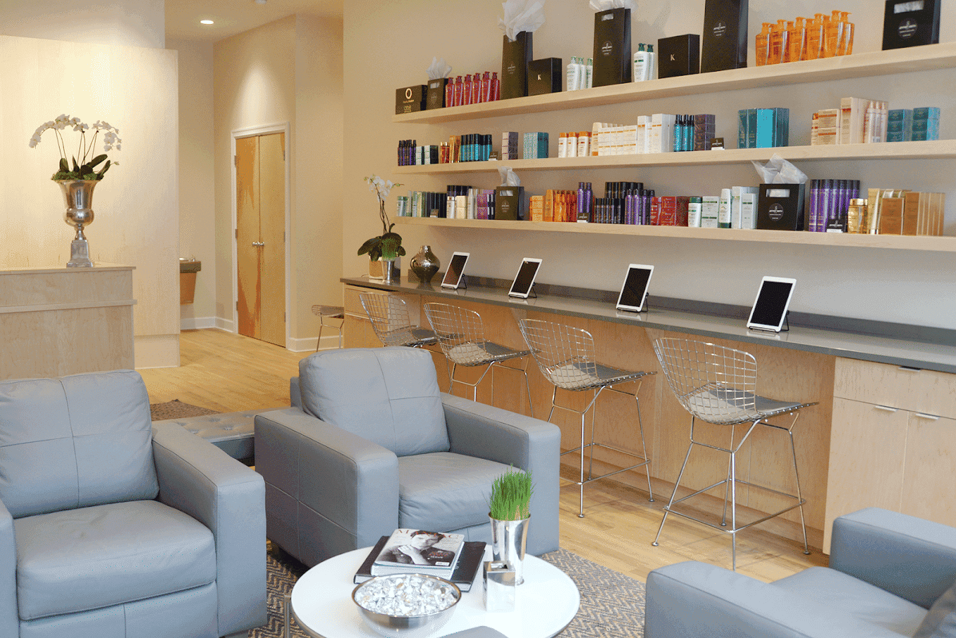 Cozy salon with modern seating and vibrant hair products displayed on shelves.